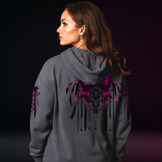 Woman wearing a gray hoodie with a purple and black design on the back against a dark background