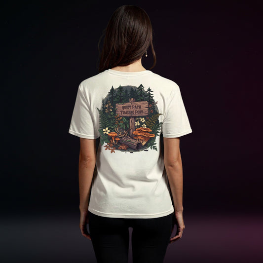 Person wearing a white t-shirt with a forest graphic on the back against a dark background