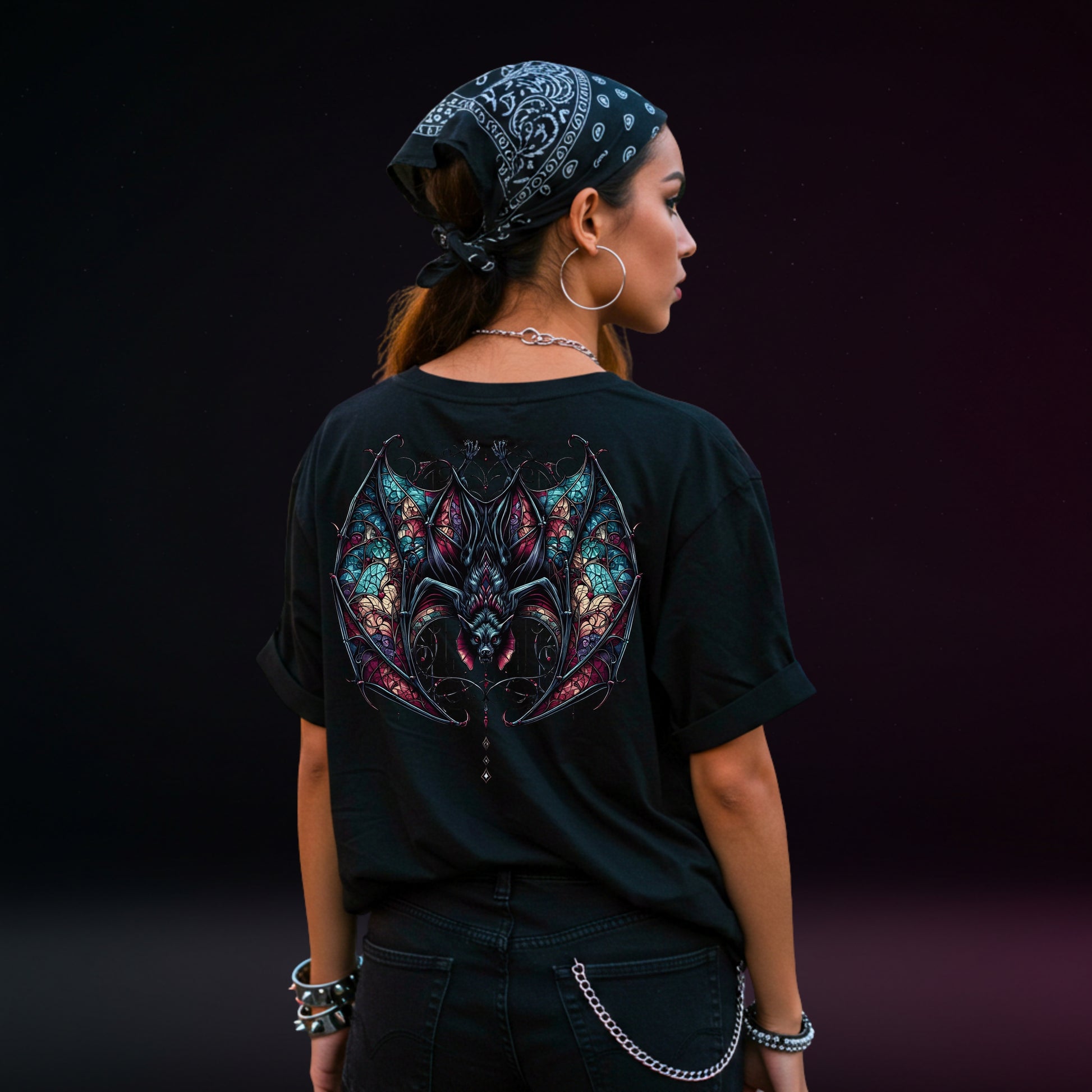 Person wearing a black t-shirt with a colorful bat design on the back against a dark background