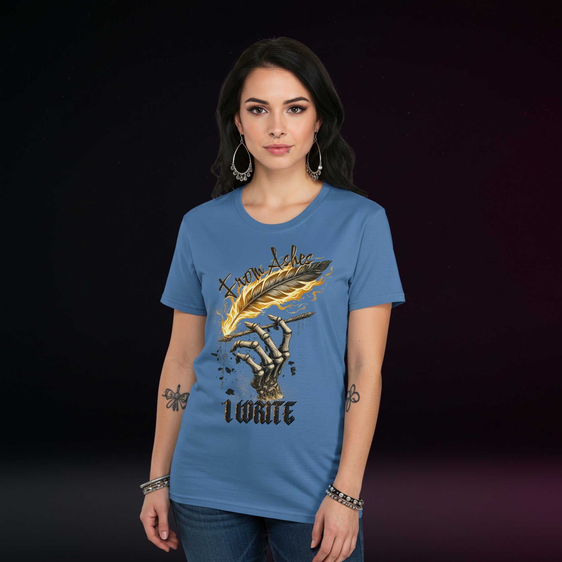 Woman wearing a blue t-shirt with a skeleton hand holding a feather quill pen on a dark background.