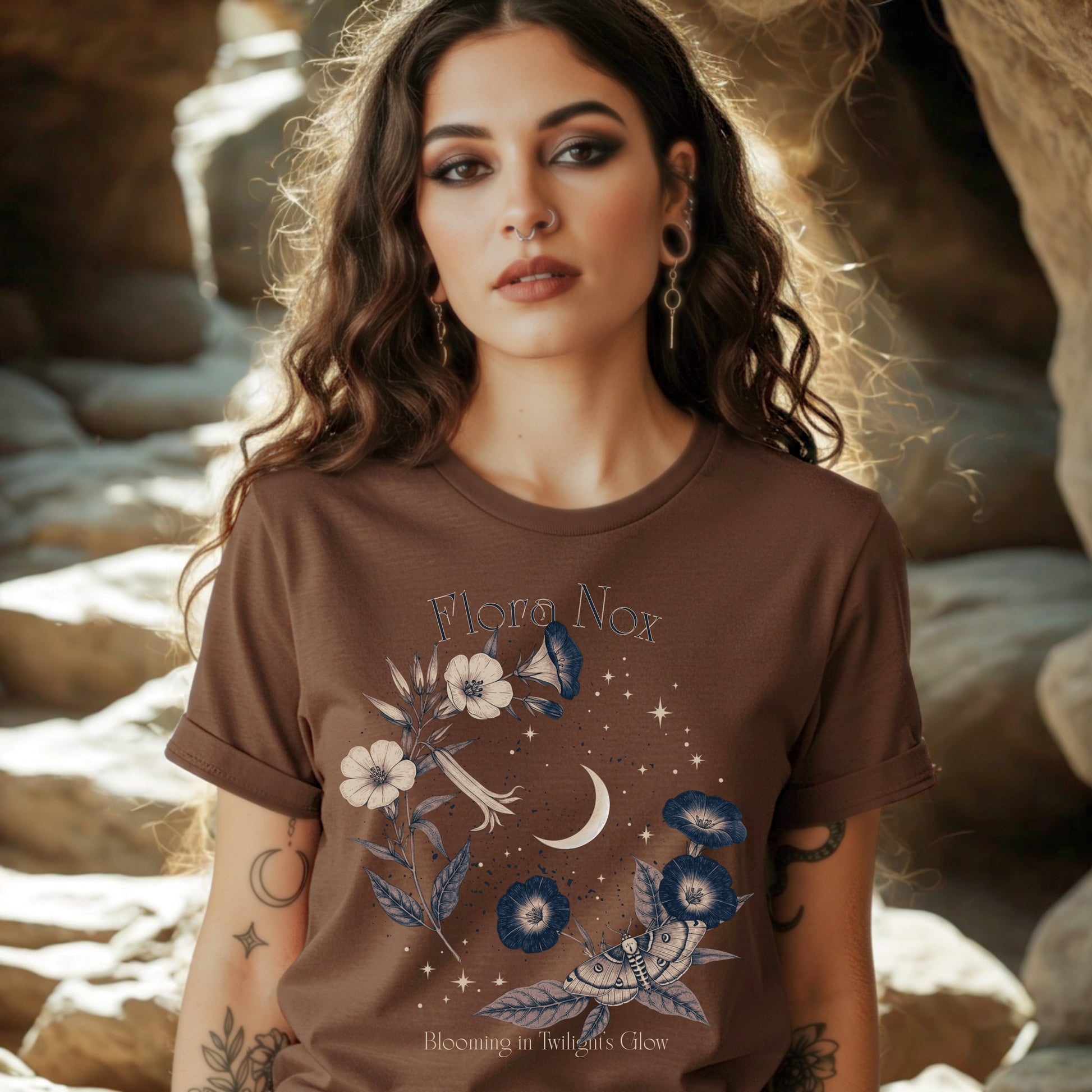 Woman wearing a brown t-shirt with floral and moon design in a natural setting