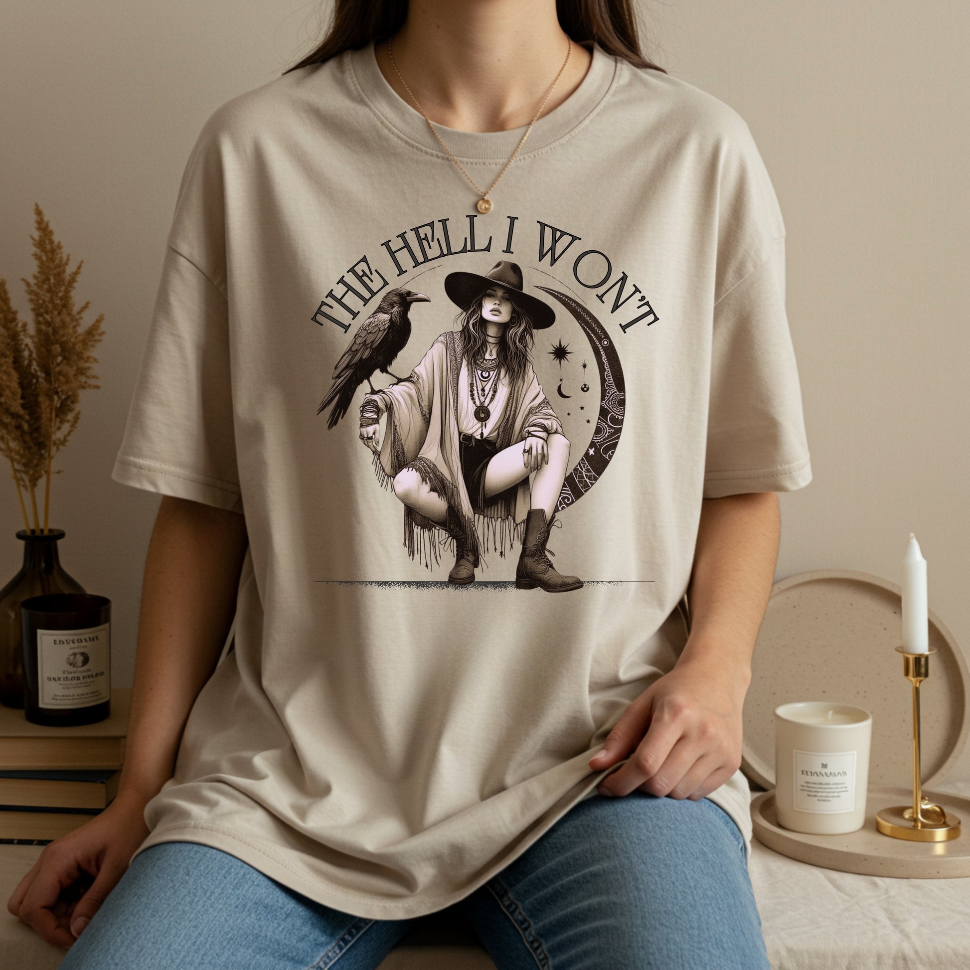Person wearing a t-shirt with a graphic design of a woman, crow, and text 'THE HELL I WON'T' in a home setting.