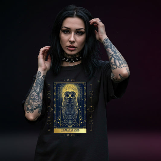 Woman wearing a black t-shirt with a tarot card owl design and text on a dark background