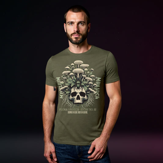 Man wearing a green t-shirt with a skull and mushroom design on a dark background