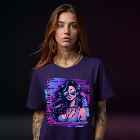 Woman wearing a purple t-shirt with a graphic design of a woman with sunglasses and text.