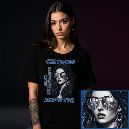 Woman wearing a black t-shirt with a graphic design of a woman wearing sunglasses and text, on a dark background.